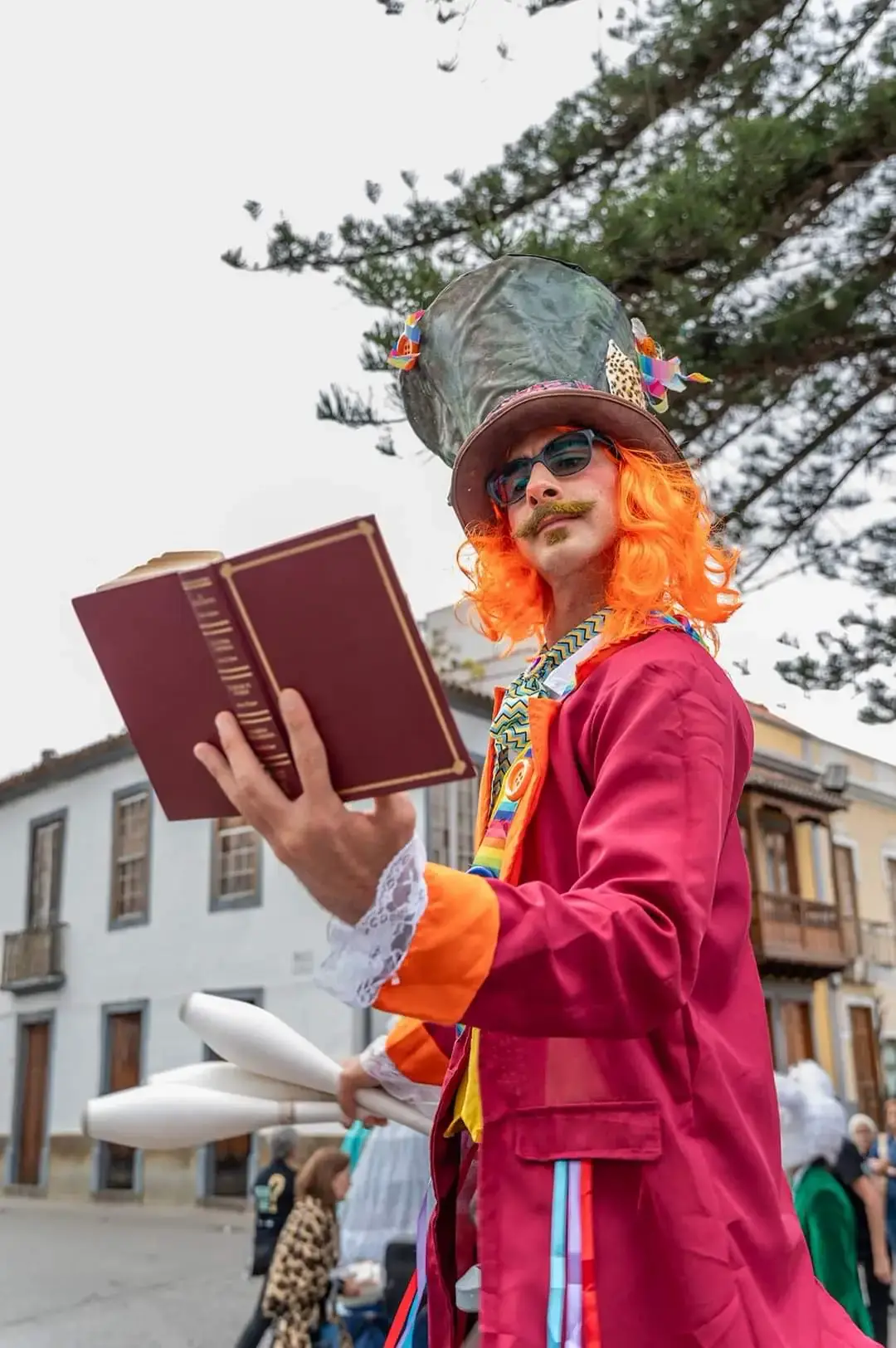 Tadeo in a colorful costume reading a book